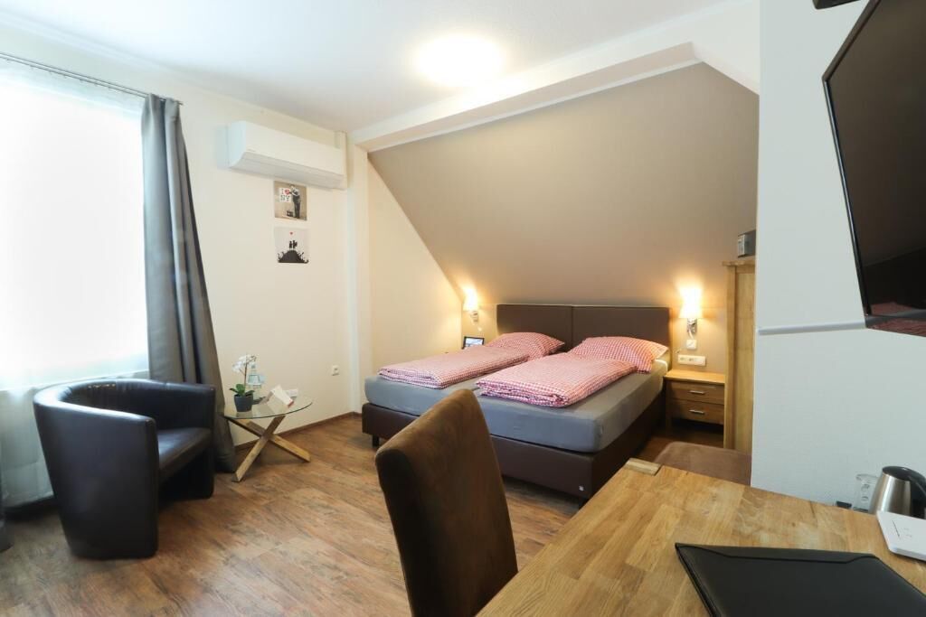 Ein gemütliches Schlafzimmer mit Bett, Nachttischen, Schreibtisch und Stuhl.