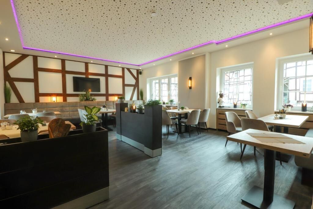 Ein modernes Interieur mit einer Rezeption, Sitzbereichen und einem Fernseher.