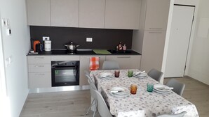 A modern kitchen with a built-in oven, a coffee maker, and a sink.