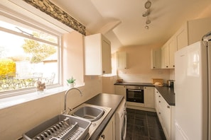 A modern kitchen with a sink, stove, and refrigerator.