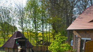 A courtyard with a brick building, a small gazebo, a stone pathway, and a central fire pit. - Himmelreich Rügen (Zirkow)