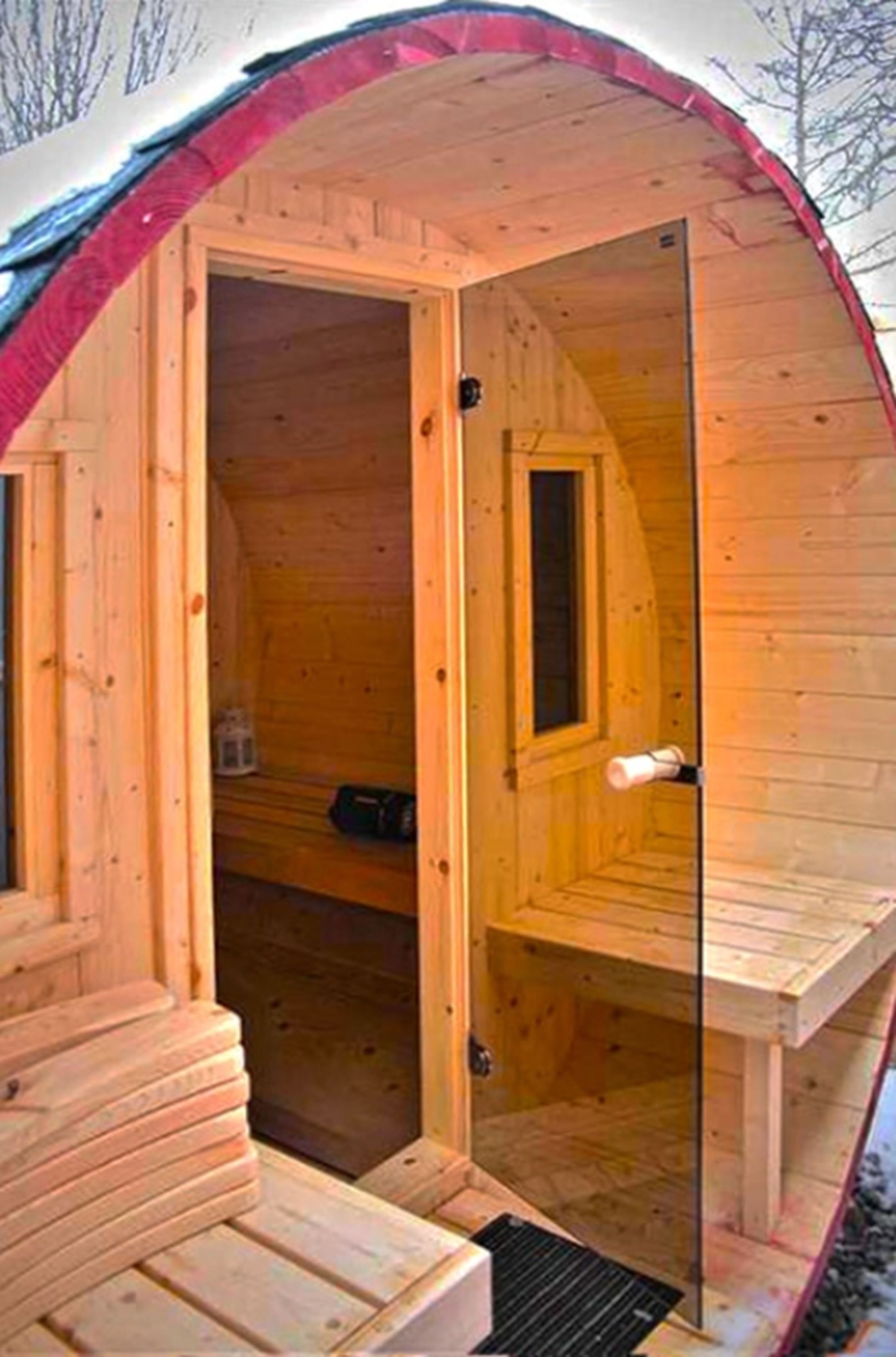 A wooden sauna with a glass door, a bench, and a window.
