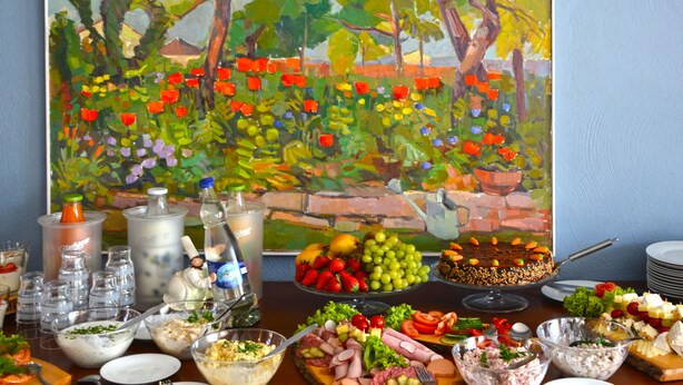 A buffet table with various food items and a painting in the background. - Himmelreich Rügen (Zirkow)