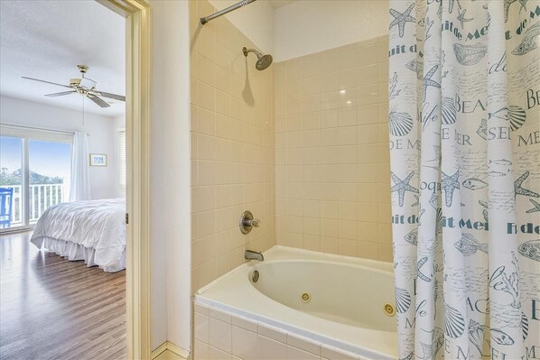 A bathroom with a bathtub, a shower, and a ceiling fan. - SOLANA MEANS 'SUNSHINE', and lovely natural lighting is just one of the amenities this home offers. (St. George Island)