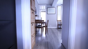 A hallway with a dining area, wooden furniture, and a ceiling with skylights. - Cosy Central Apartments - Oxford Street (London)