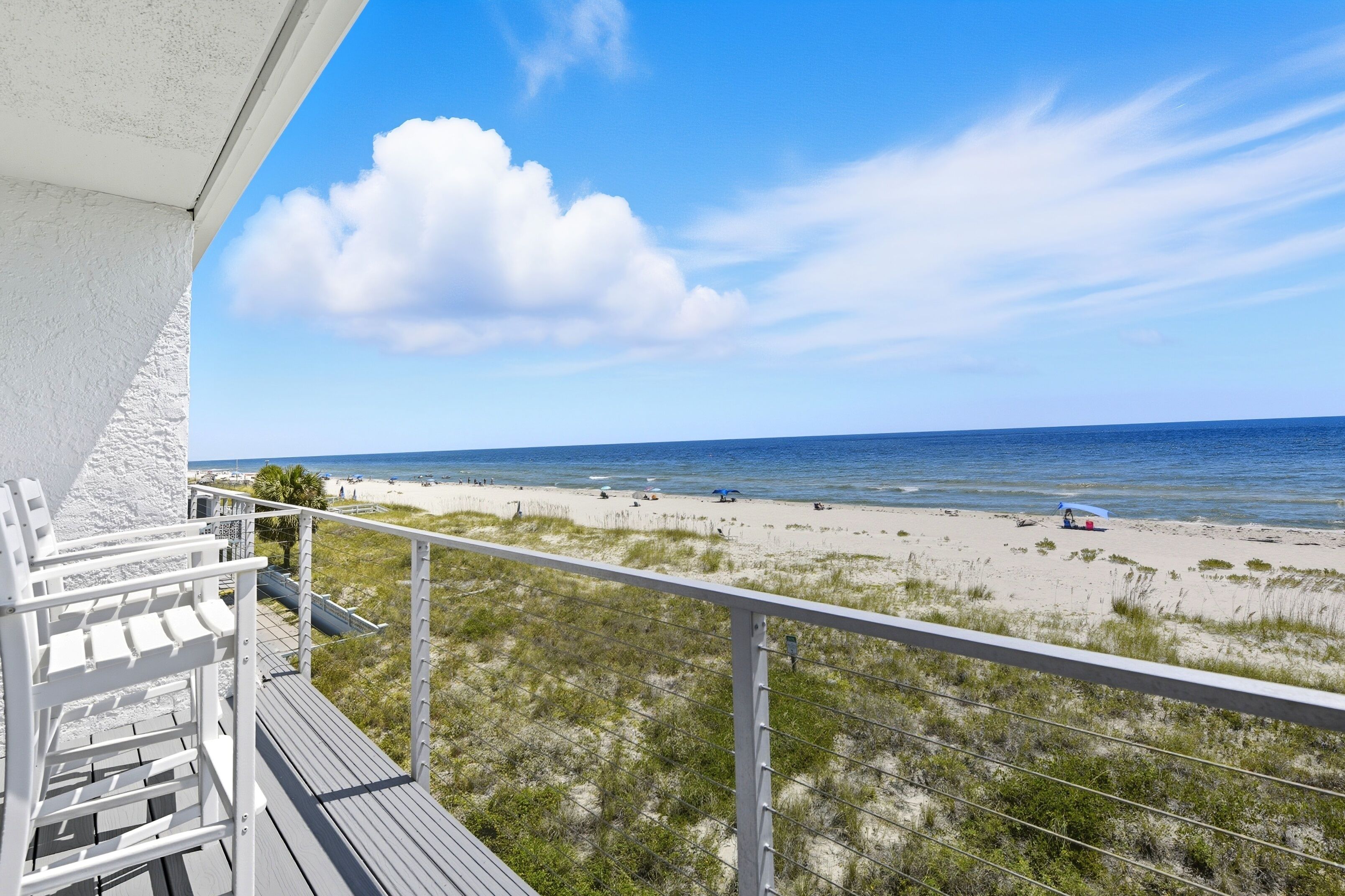 Un balcon avec vue sur une plage et l’océan.