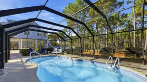 A swimming pool with a covered area, surrounded by trees and a house in the background. - WELCOME to our house, HEATWAVE for an unforgettable beach experience on beautiful St. George Island. (St. George Island)