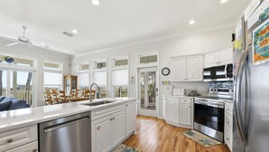 A modern kitchen with white cabinets, stainless steel appliances, and a wooden floor. - WELCOME to our house, HEATWAVE for an unforgettable beach experience on beautiful St. George Island. (St. George Island)