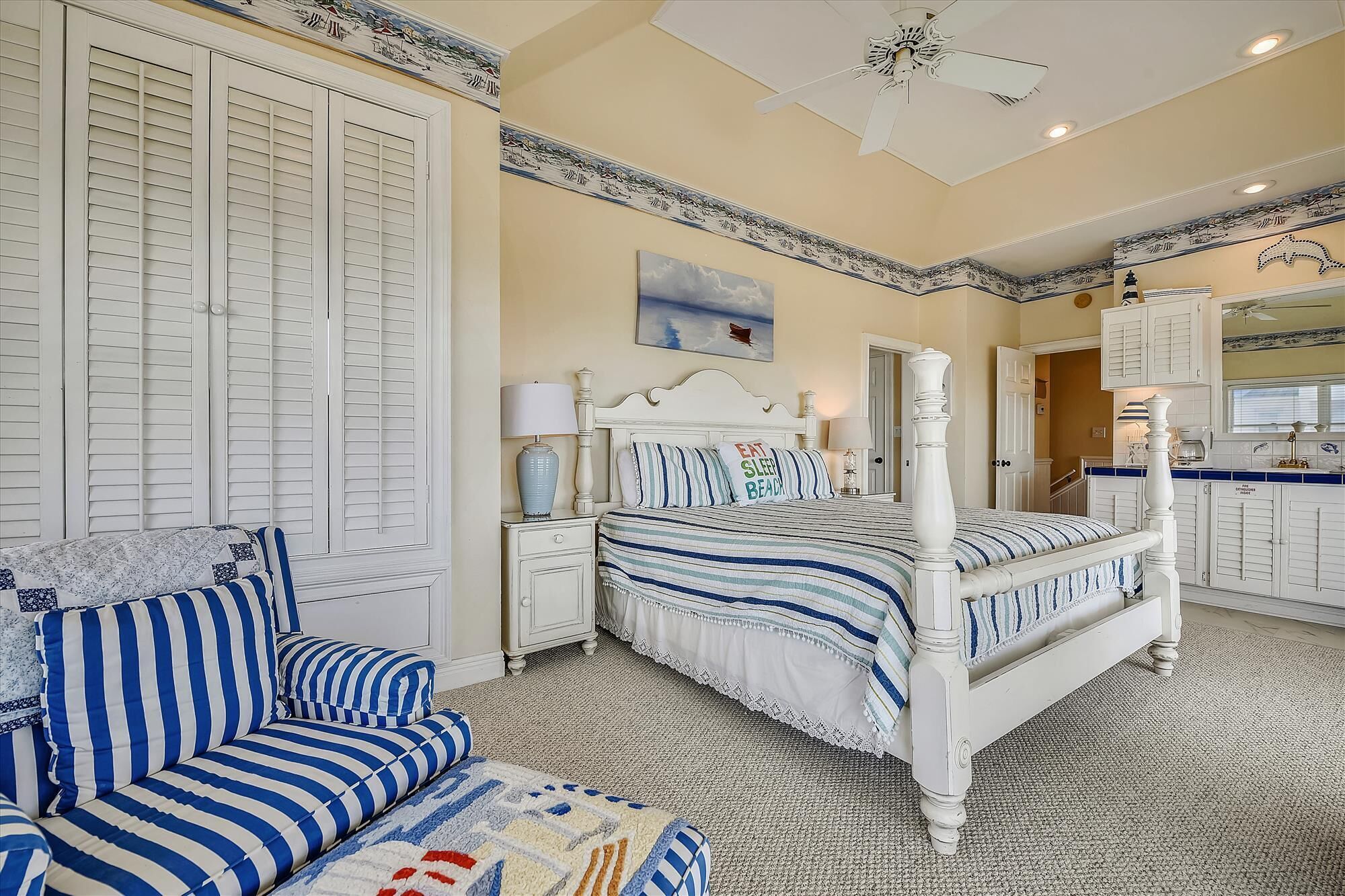 A bedroom with a bed, a nightstand, a lamp, a chair, and a dresser.