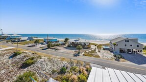 A beachfront property with multiple houses, a road, and a beach.