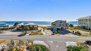 A coastal property with multiple buildings, a beach, and a clear view of the ocean.