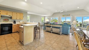 Cocina amplia con isla central, armarios de madera y un ventanal con vistas al exterior.