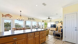 Una cocina amplia con una isla grande, armarios de madera y vistas al exterior.