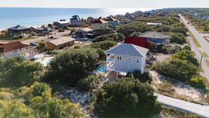 Zona residencial costera con casas, piscina y vista al mar.