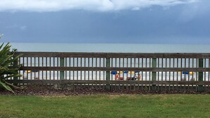 A wooden fence with a view of the beach and ocean.