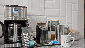 A coffee maker, a bag of Bongo blend coffee, a glass carafe, a coffee grinder, and a mug on a kitchen counter. - PRISTINE PROPERTY IN PRIME LOCATION — CHARMING ☆ SAFE ☆ WALK TO EVERYTHING (Nashville)