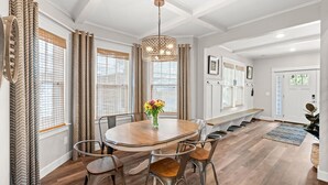 A dining area with a round table, chairs, a chandelier, and a bench. - PRISTINE PROPERTY IN PRIME LOCATION — CHARMING ☆ SAFE ☆ WALK TO EVERYTHING (Nashville)
