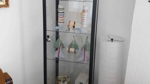 Une vitrine en verre contenant divers objets, notamment des bouteilles et des boîtes.