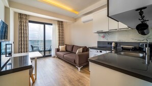 A modern apartment with a living area, kitchen, and balcony. - Ece Marina Suites (Fethiye)