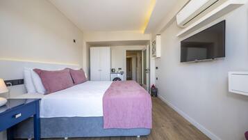 Ein modernes Hotelzimmer mit Bett, Schreibtisch, Flachbildfernseher und Klimaanlage.