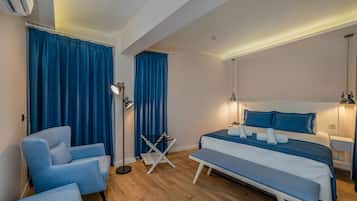 Un dormitorio moderno con una cama, una silla, un banco, una lámpara de pie y una mesita.