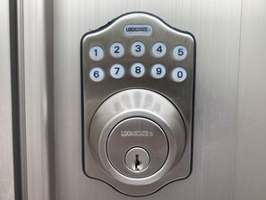 A keypad lock with numbers 0-9 and a central lock button, branded with "Lockstate".
