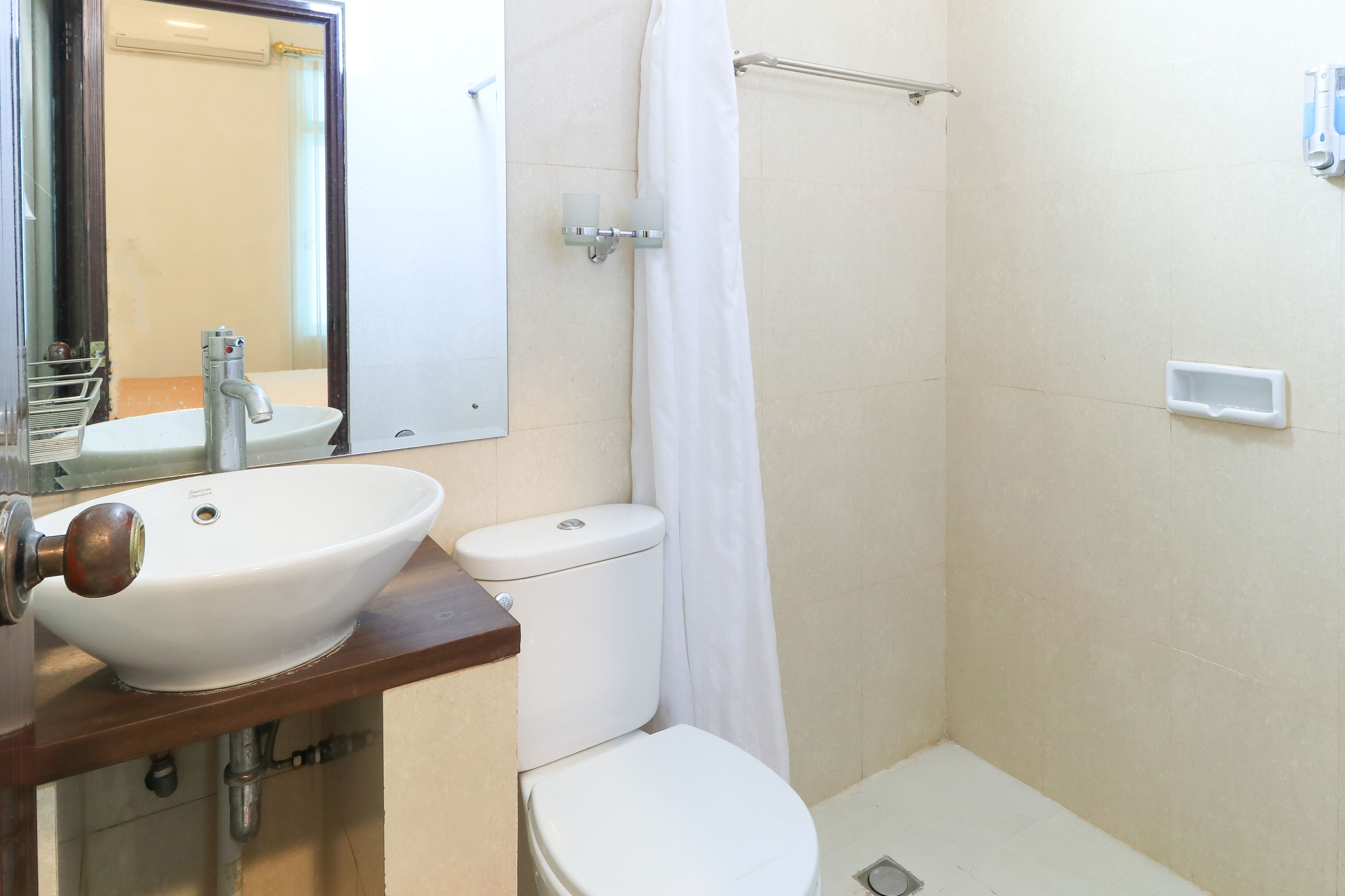 A bathroom with a white sink, toilet, and shower curtain.