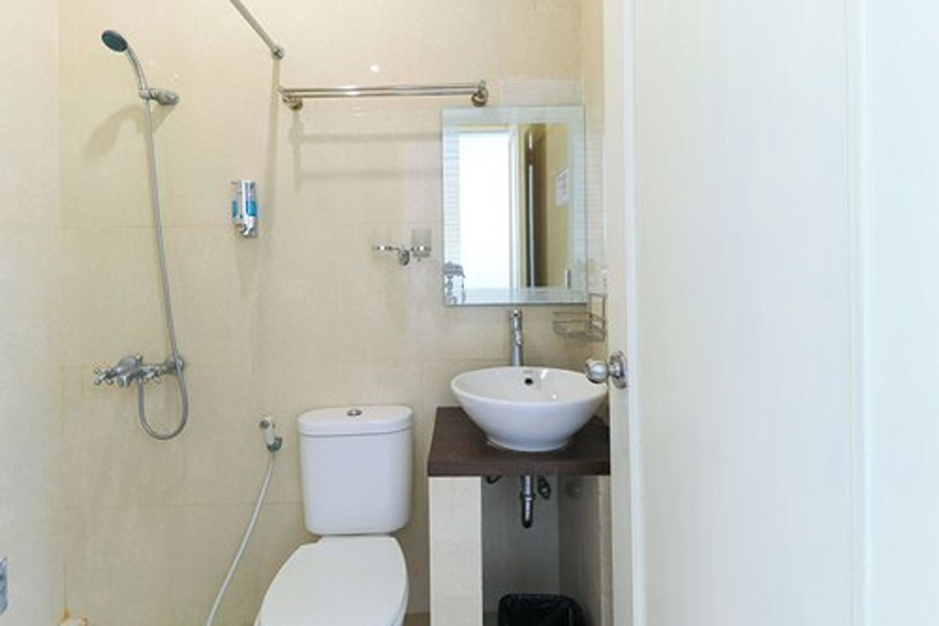 Un baño pequeño con inodoro, lavamanos y ducha.