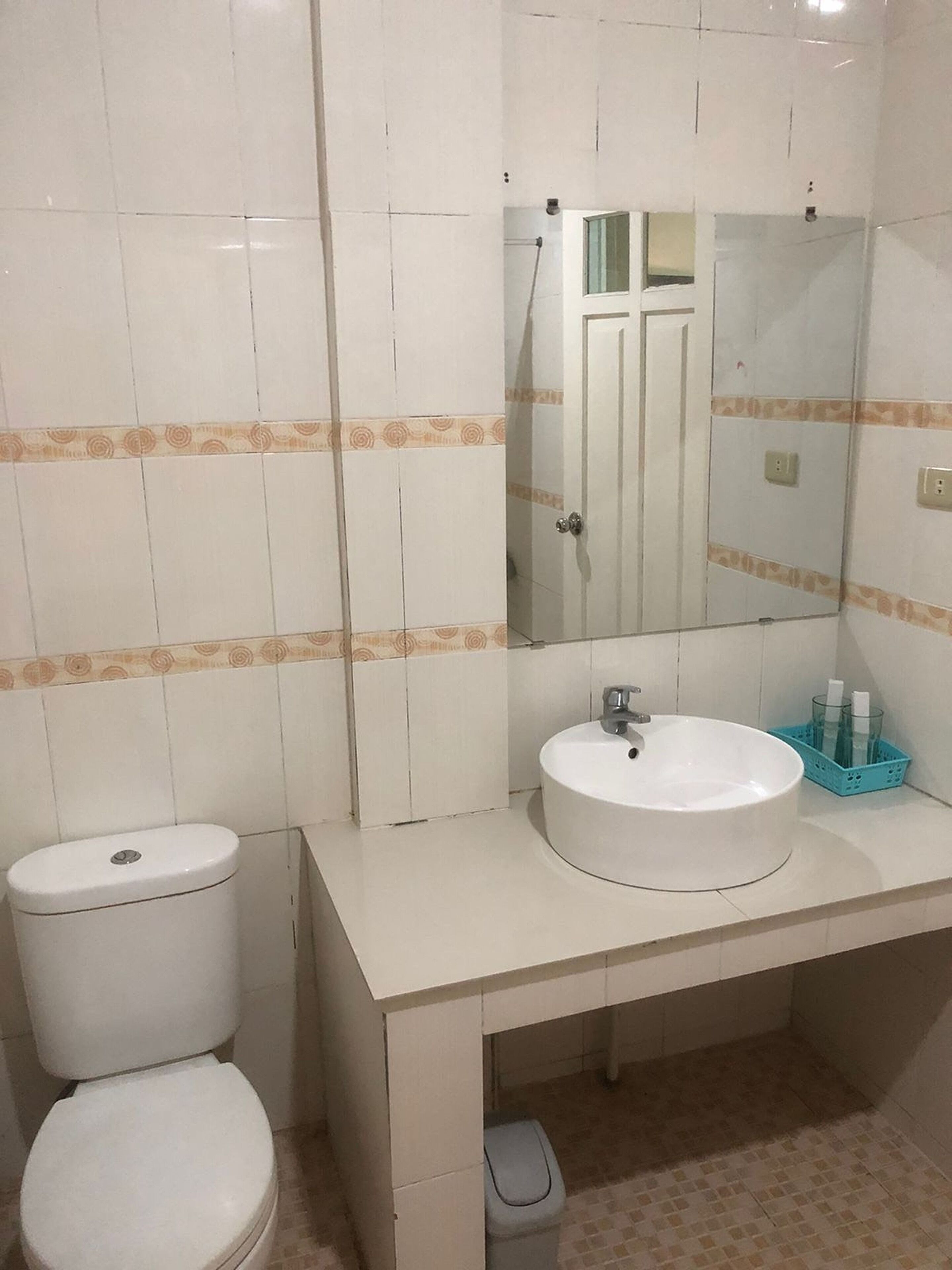 Kylpyhuone, jossa on wc, pesuallas ja peili.