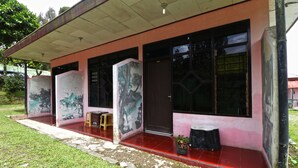 A building with a red tiled floor, a covered porch, and large windows. - Bangkit Nan Jaya (Berastagi)