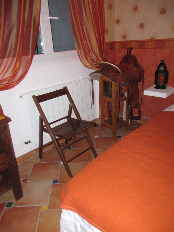 A room with a bed, a wooden chair, a small table with a lamp, and a radiator. - Chambres d'hotes au pays de Fayence (Tourrettes)
