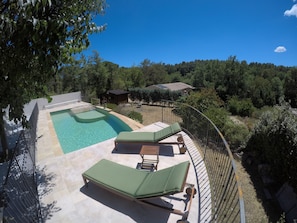 A pool area with two lounge chairs and a small building in the background. - Chambres d'hotes au pays de Fayence (Tourrettes)