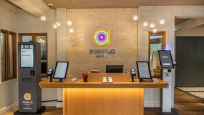 Un mostrador de recepción con un logotipo, un quiosco digital y una máquina de autoservicio.