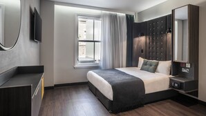 Una habitación de hotel moderna con una cama grande, un armario empotrado, un televisor de pantalla plana y una ventana con cortinas.