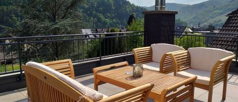 Un balcone con mobili in legno e vista su un paesaggio montano.