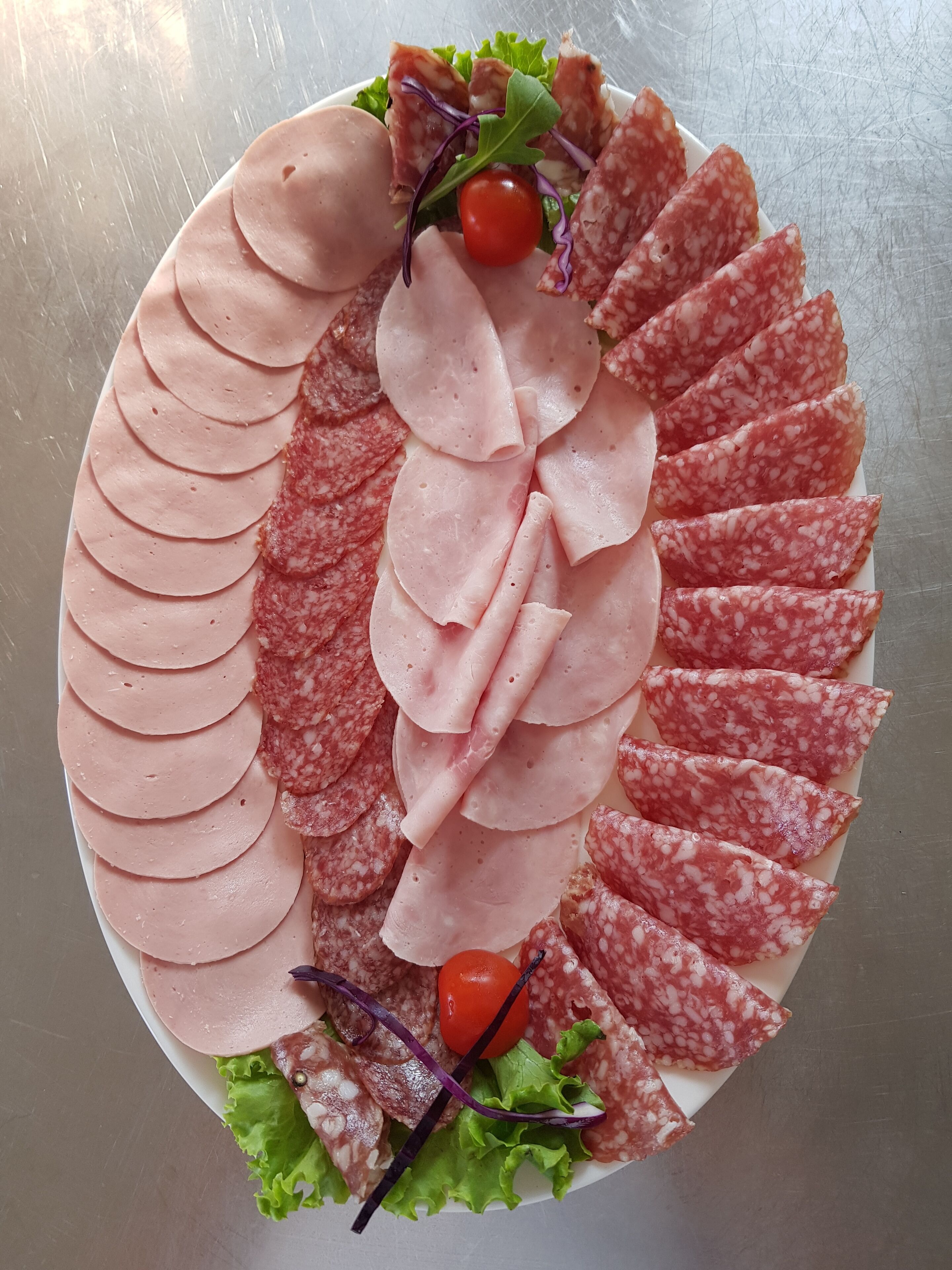 Una bandeja con carnes y verduras cortadas.