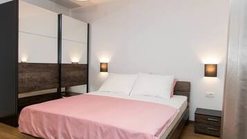 Un dormitorio moderno con cama, mesitas de noche e iluminación en la pared.