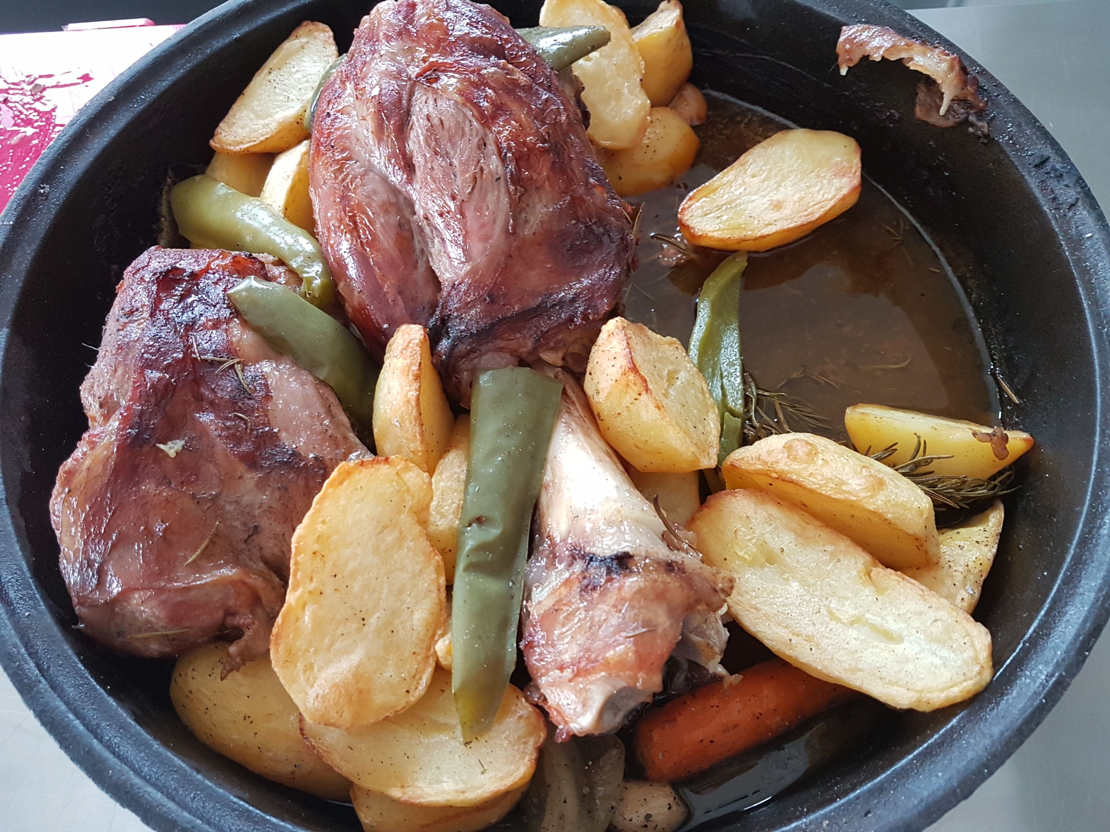 Una olla con carne asada, patatas y judías verdes.