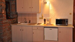 Eine kleine Küche mit Spüle, Mikrowelle und Kaffeemaschine.