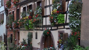 Ein traditionelles Fachwerkhäuschen mit Blumenkästen an der Fassade.