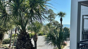 A view of a street lined with palm trees and a building with a balcony. - Elegance at the beach -Ocean View Villa, Gorgeous! (Hilton Head Island)