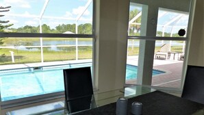 Een kamer met uitzicht op een zwembad en een terras.