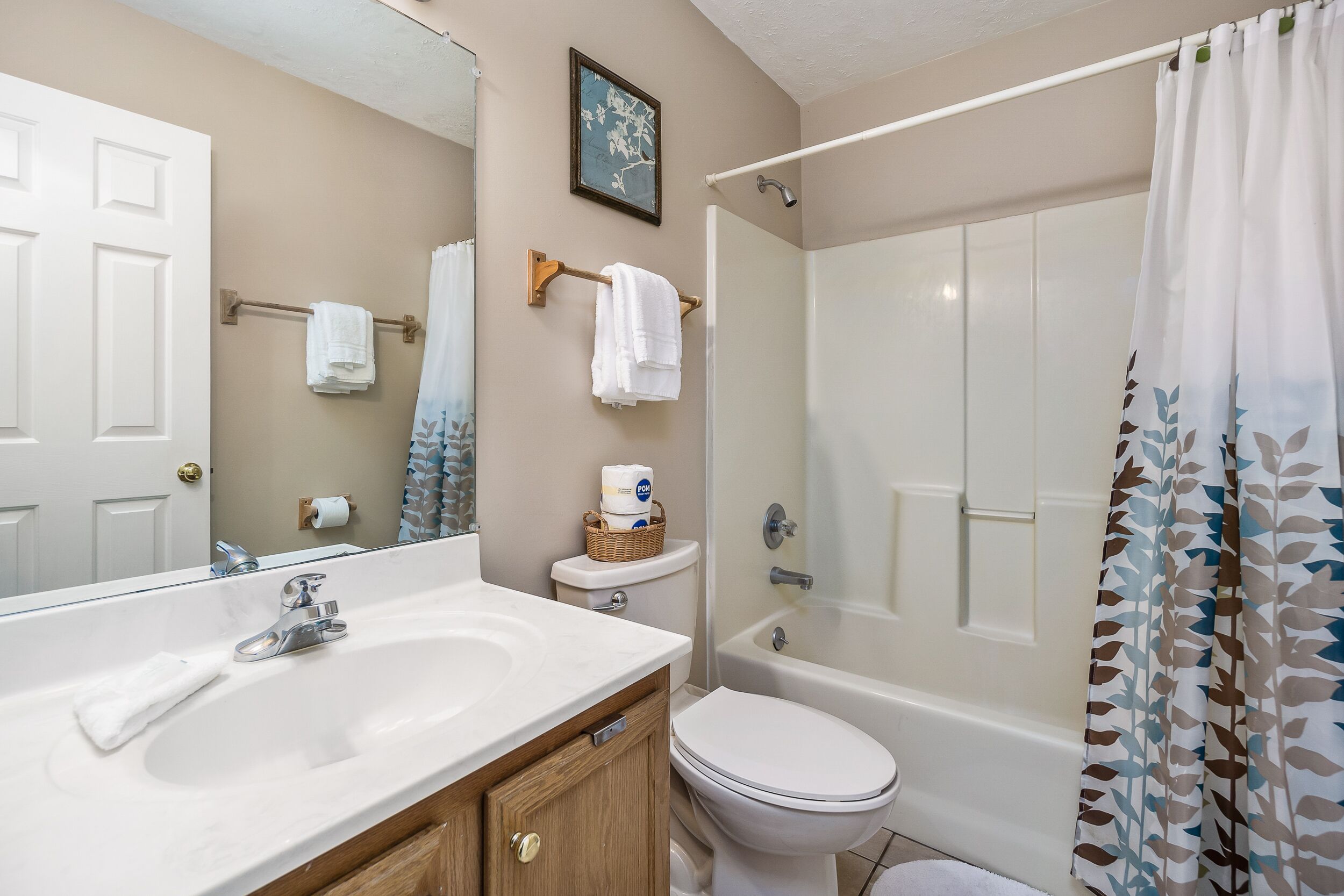 Une salle de bain équipée d’un lavabo, d’un miroir, de toilettes et d’une douche.