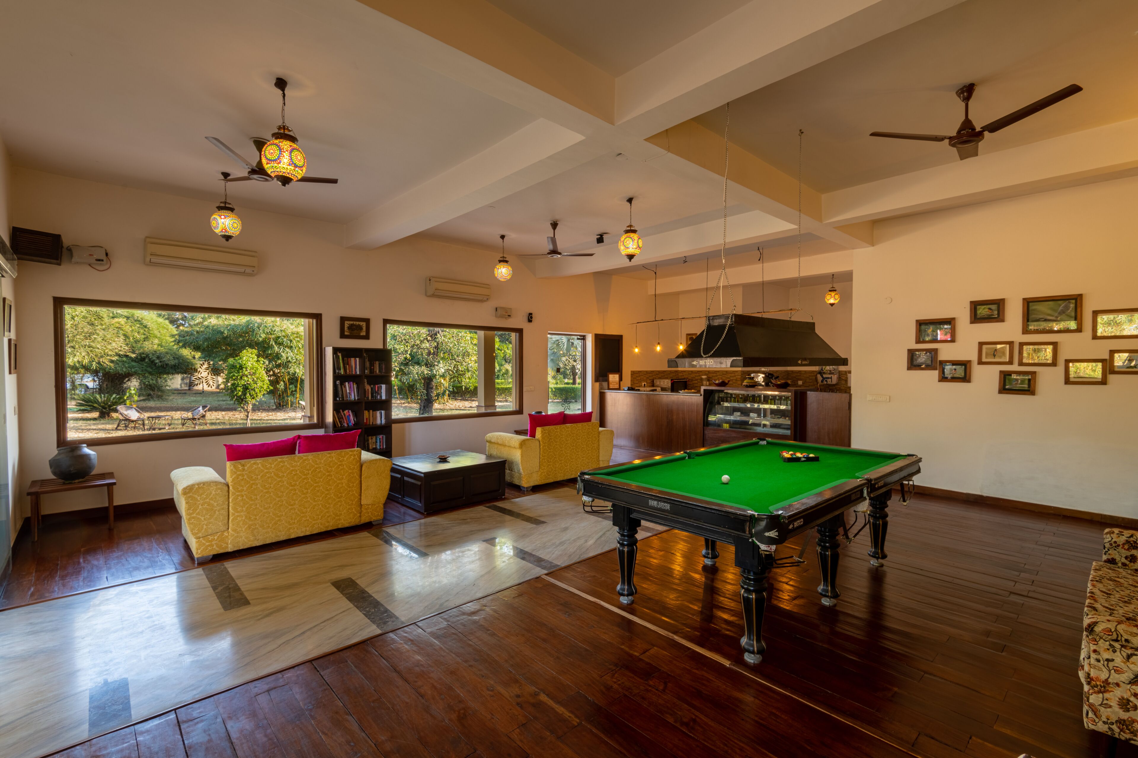 Amplia habitación con mesa de billar, sofá y estantería.