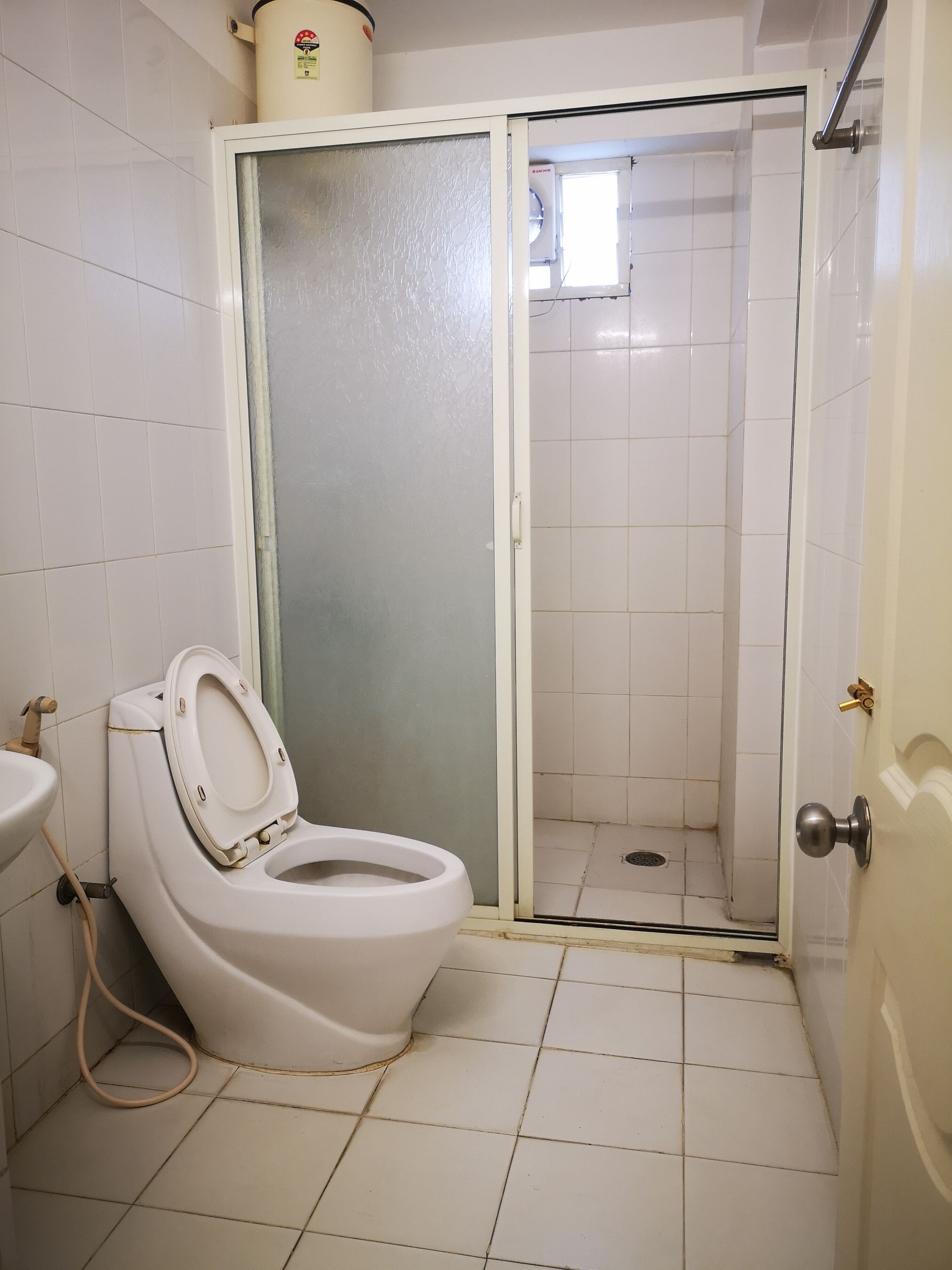 A bathroom with a toilet, a sink, and a shower area.