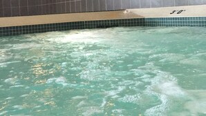 A swimming pool with a tiled wall and a clock. - MUST STAY very big space (Aurora)