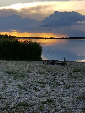 A gravel area with a bicycle and a body of water in the background. - Warias Hotel & Restaurant (Braunsbedra)