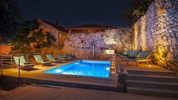 Una piscina al aire libre de temporada, sillones reclinables de piscina