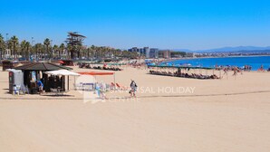 Une plage avec un kiosque, des parasols et des chaises de plage.