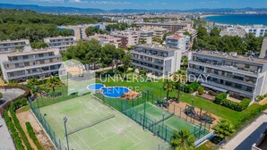 Un quartier résidentiel avec des immeubles d’appartements modernes, un court de tennis et une piscine.